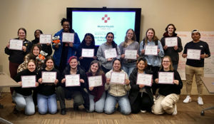 Mental Health First Aiders pose with their completion certificates.